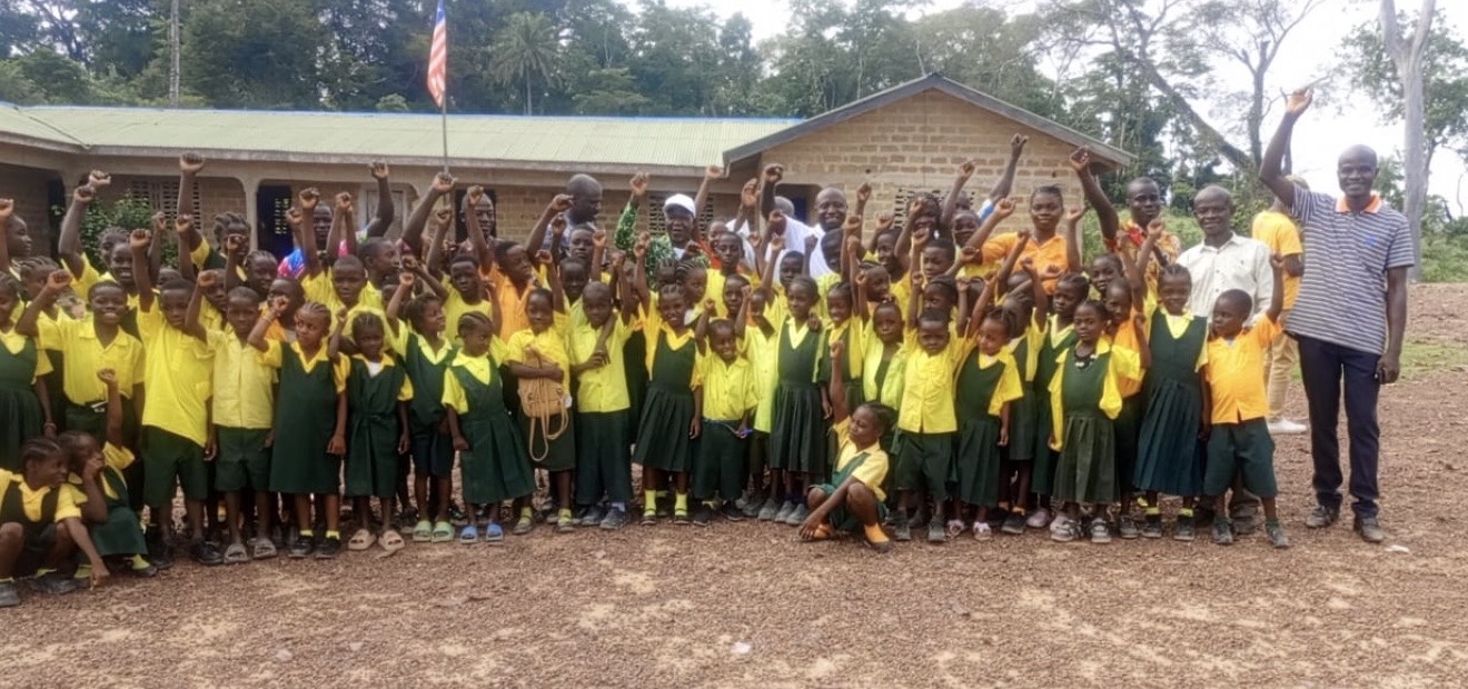 Liberian students cheering in front of their school